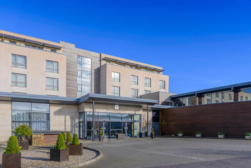 un edificio con un estacionamiento delante de él en Manor West Hotel & Leisure Club en Tralee