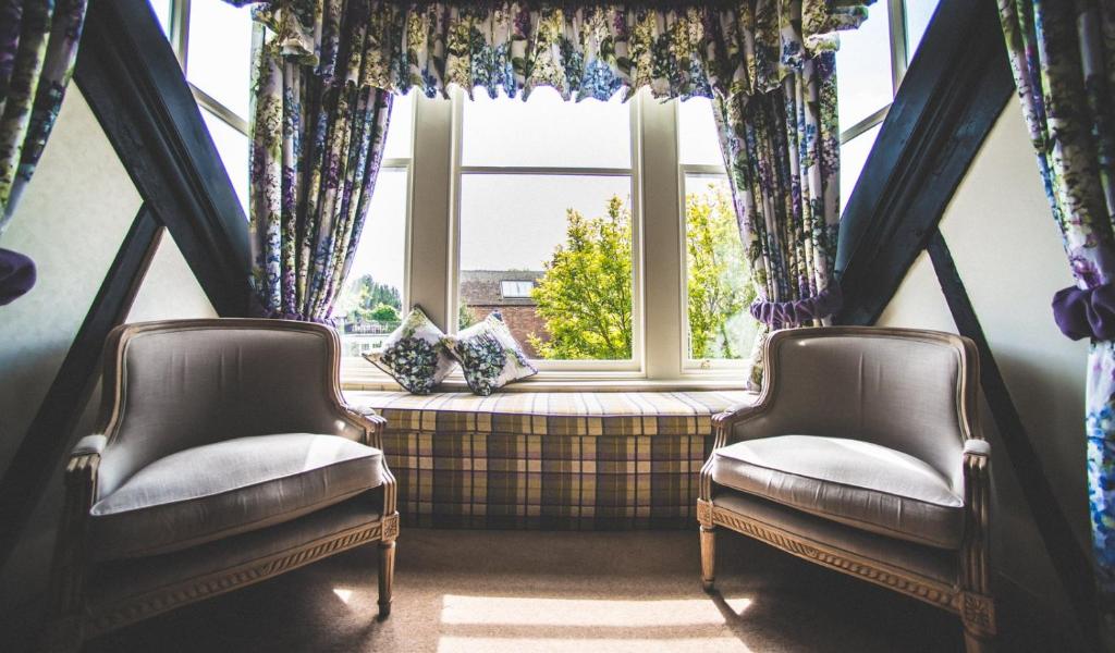 two chairs sitting in front of a window at Jeakes House in Rye