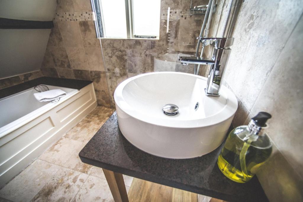 a bathroom with a white sink and a bath tub at Jeakes House in Rye