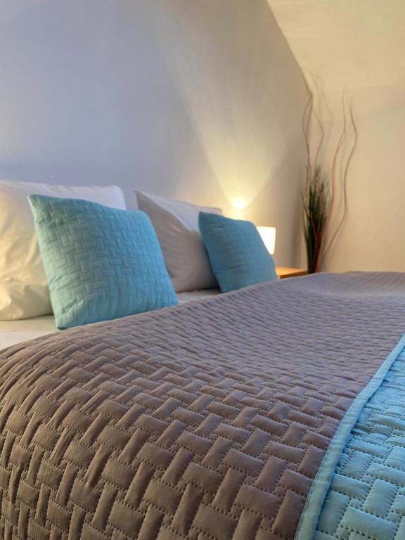 1 dormitorio con 1 cama con almohadas azules y blancas en Apartmán Ivka en Brezno