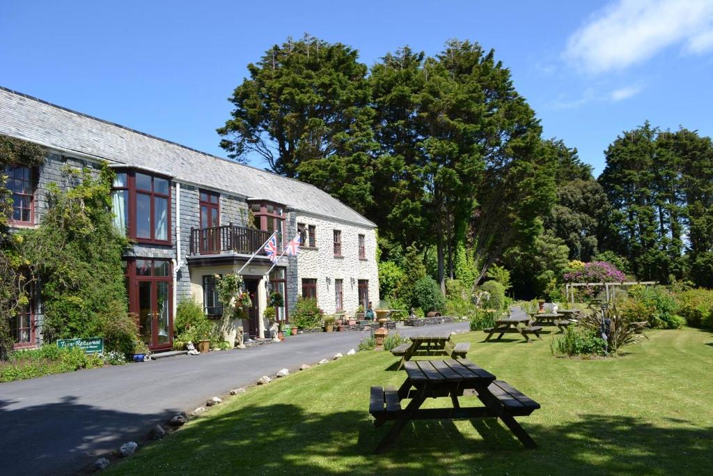 a park with benches in front of a building at Trimstone Manor Country House Cottages in Ilfracombe