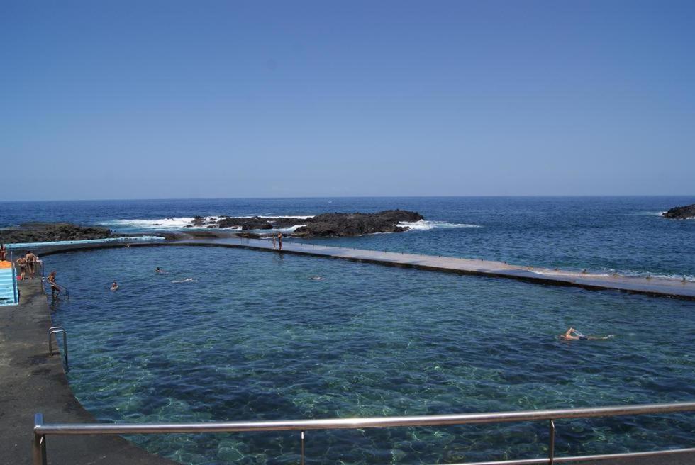 a swimming pool in the ocean with people in it at Casa RITI Mesa del Mar in Tacoronte