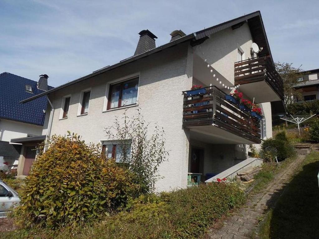 ein weißes Haus mit einem Balkon an der Seite in der Unterkunft Ferienwohnung Paul und Maria in Olsberg