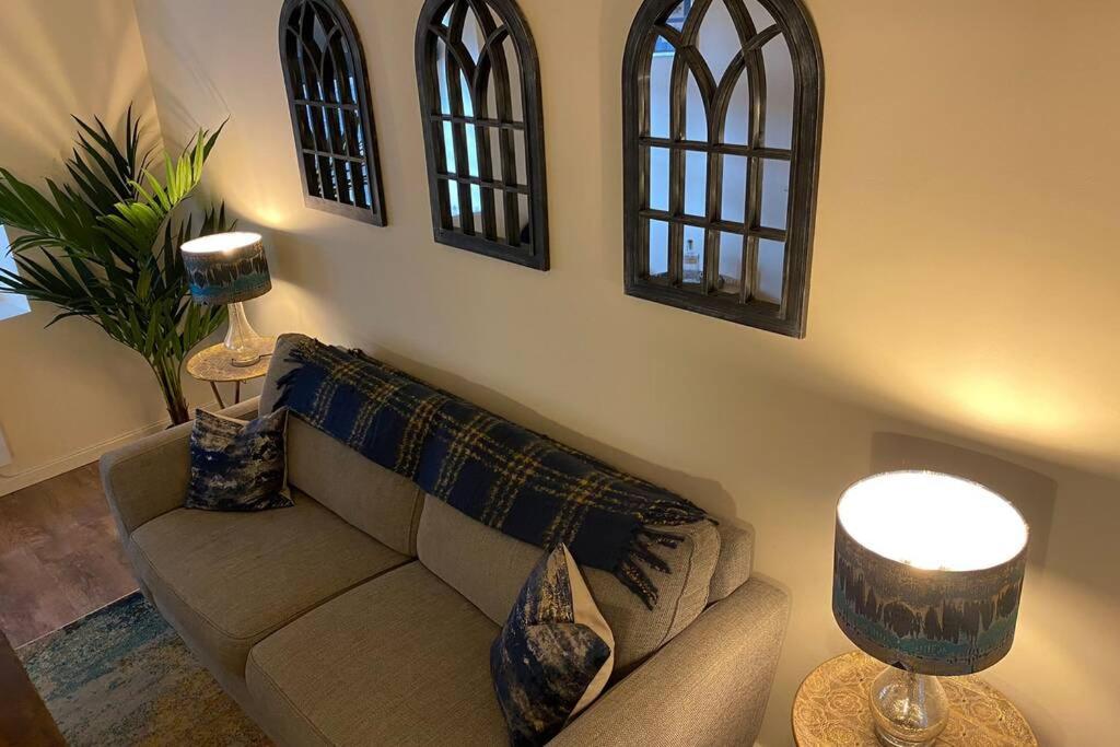 a living room with a couch and a lamp at The Old Jail Apartment, Inveraray in Inveraray