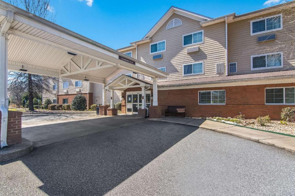 a building with a covered driveway in front of it at MainStay Suites Columbus next to Fort Moore in Columbus