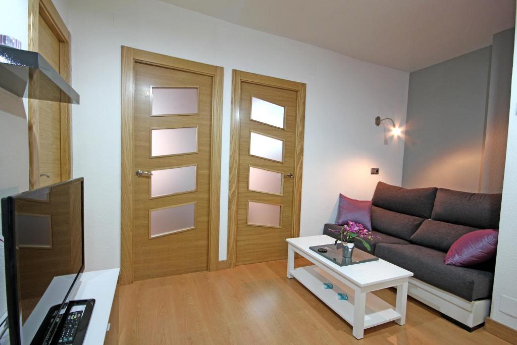 een woonkamer met een bank en een tafel bij Apartamento Berria in Pamplona