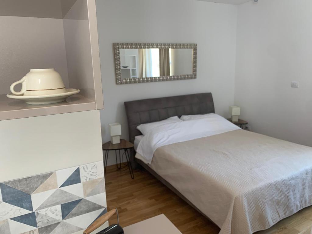 una camera da letto con un letto e uno specchio a parete di Madonna Guesthouse II a Dubrovnik