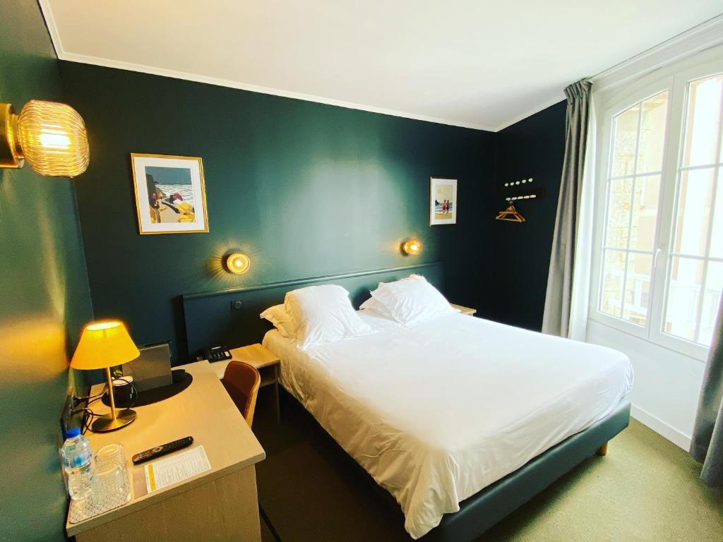 sypialnia z łóżkiem i biurkiem z szafką nocną w obiekcie Hotel du Parc w mieście Dinard