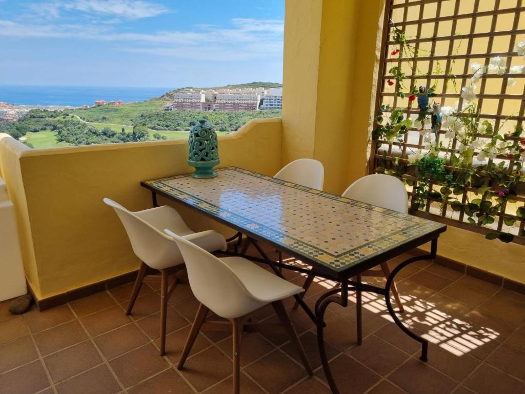 a table and chairs in a balcony with a view of the ocean at Duquesa Village in Manilva