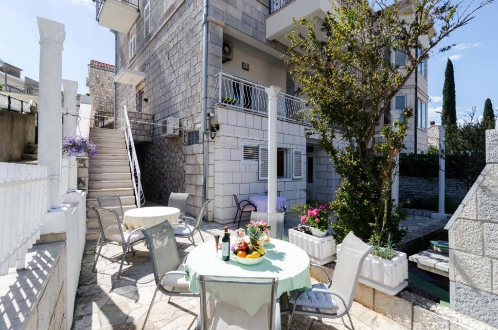 eine Terrasse mit einem Tisch und Stühlen sowie ein Gebäude in der Unterkunft Guest House Ćuk in Dubrovnik