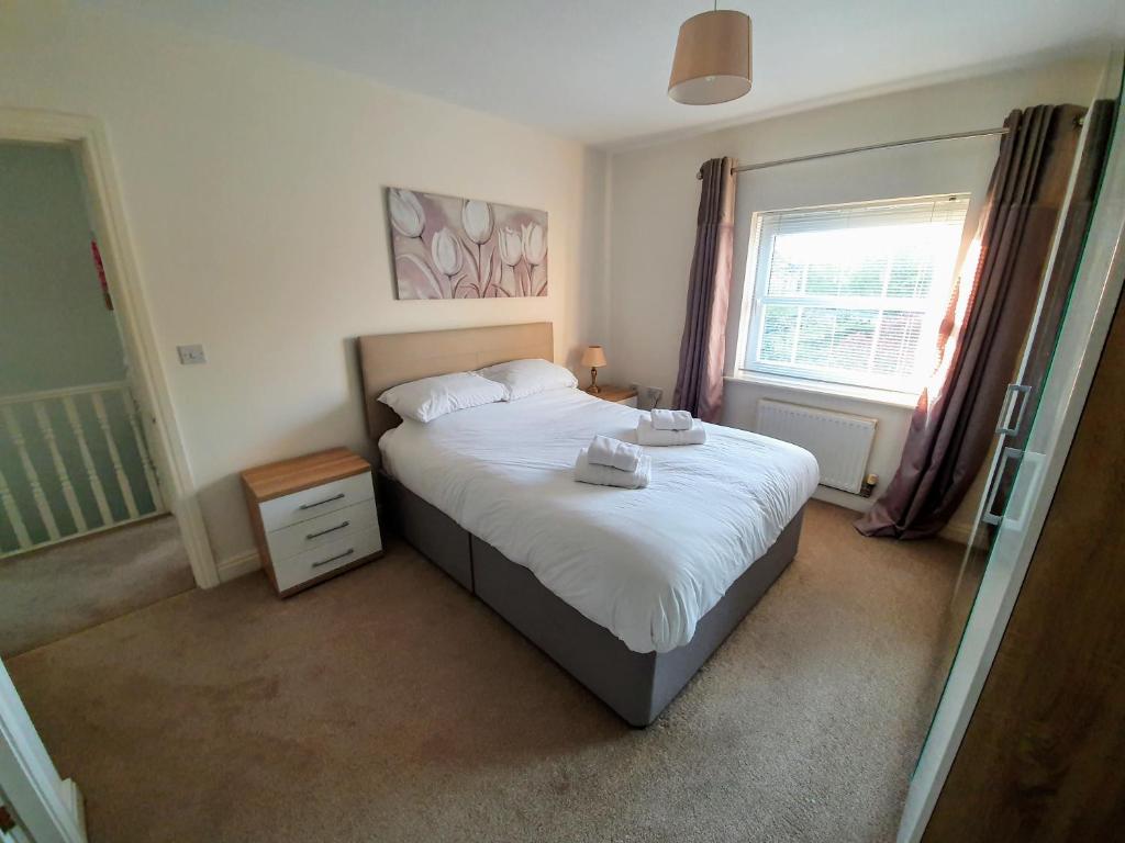 貝弗利的住宿－Beverley Central Townhouse Free Parking Sleeps 8，一间卧室配有一张带白色床单的床和一扇窗户。