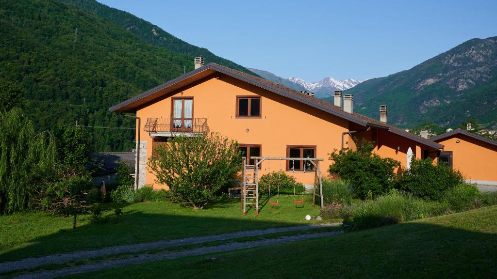 an orange house with a staircase in a yard at B&B 'L Cumbalot in Pinasca 