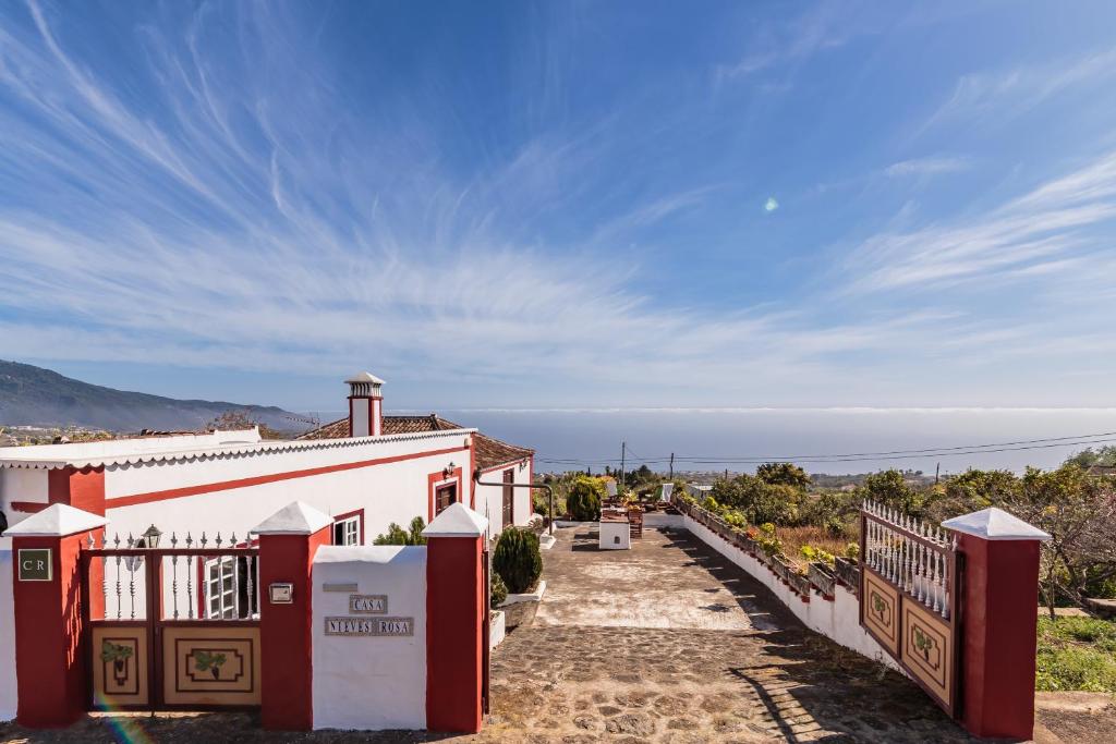 a red and white house with a pathway leading to it at Nieves Rosa in Botazo
