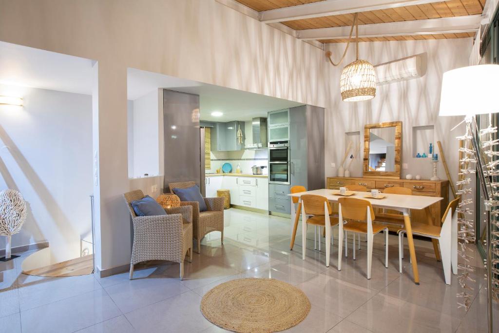 een keuken en eetkamer met een tafel en stoelen bij SKAI Two Floor Apartment in Vasiliki