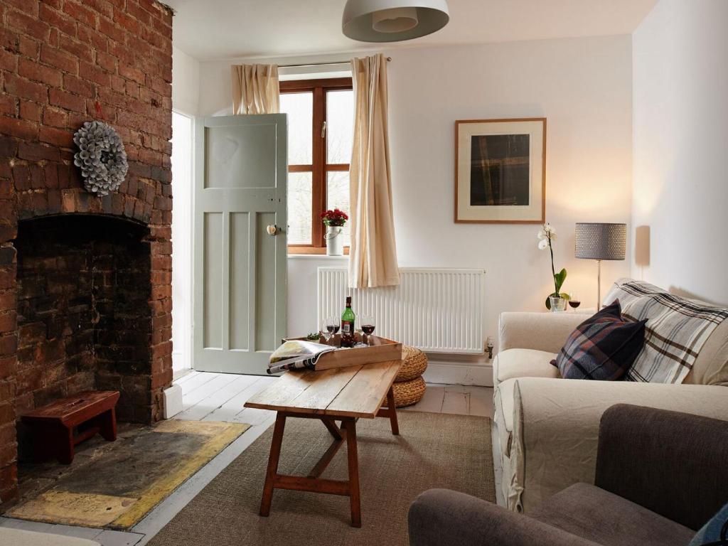 uma sala de estar com um sofá e uma lareira em Small Brook Cottage em Hay-on-Wye