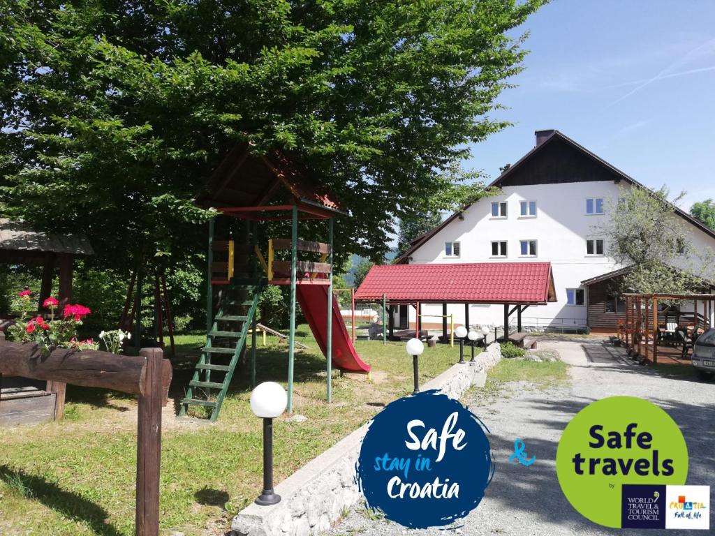einen Spielplatz mit Rutsche und Spielstruktur in der Unterkunft Guesthouse Arnika in Fužine