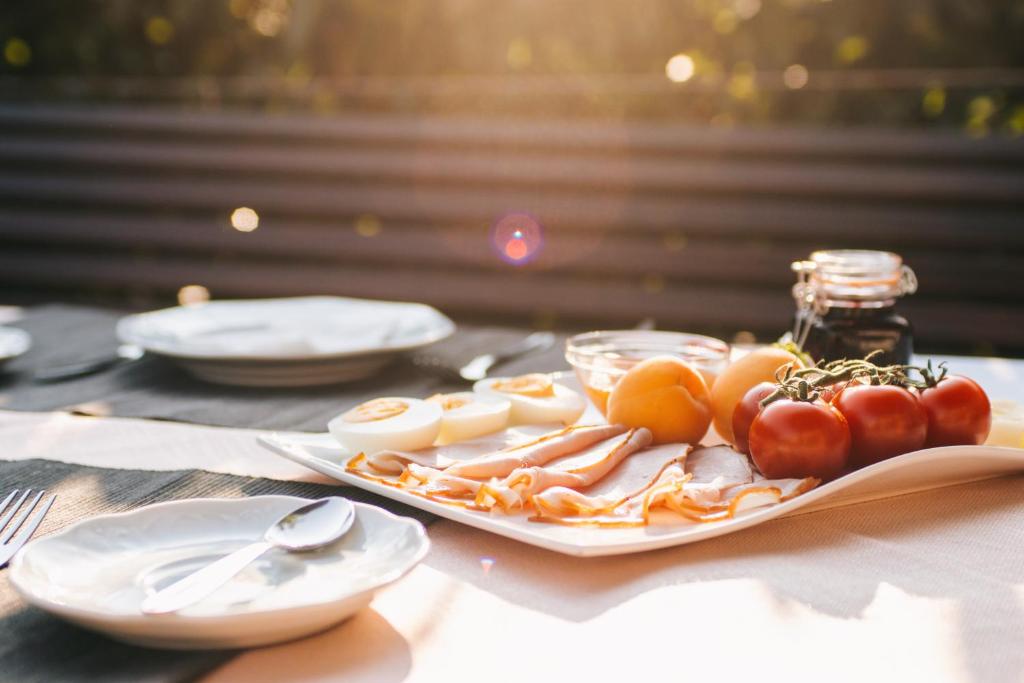 ein Teller mit Lebensmitteln auf einem Tisch mit Tomaten und Käse in der Unterkunft Rooms 73 - Helga Bartos in Pörtschach am Wörthersee