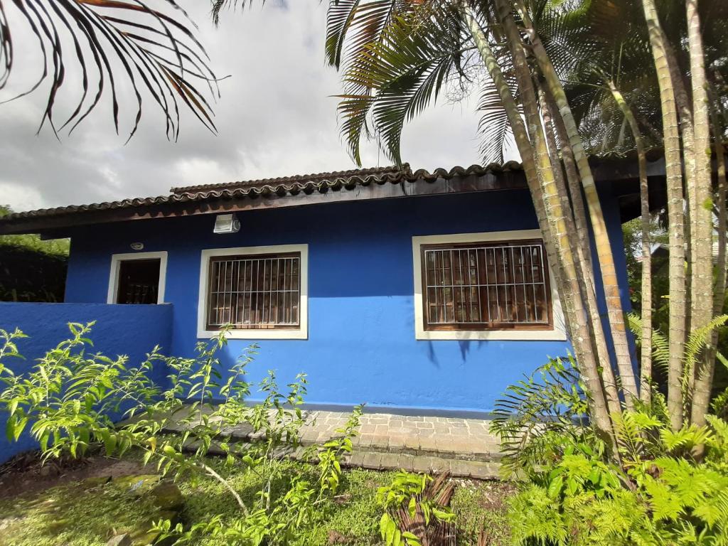 a blue house with windows and a palm tree at Juquehy a 200m da praia, Wifi, Churrasqueira in São Paulo