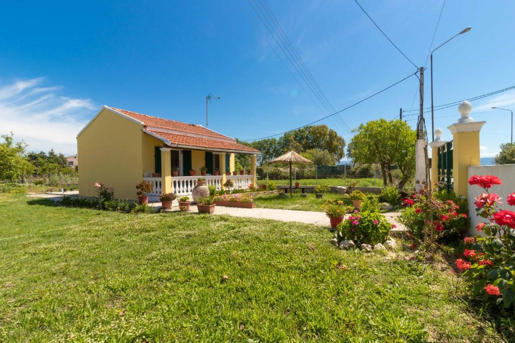 a small house with a porch and a yard at Teta's Holiday Home in Melíkia