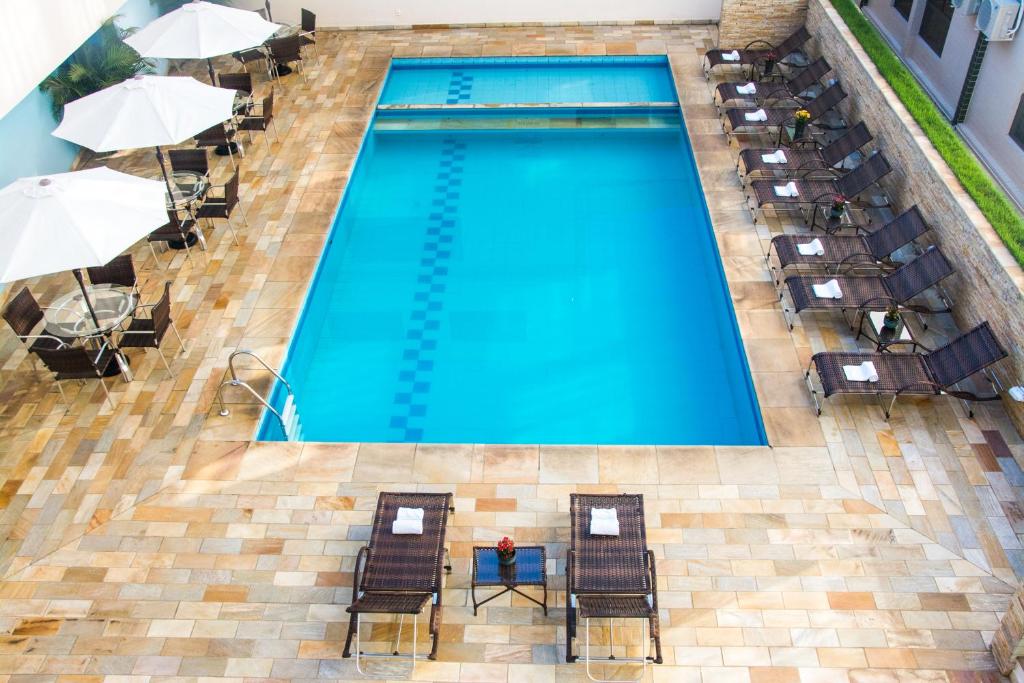 an overhead view of a swimming pool with chairs and umbrellas at Serra Negra Palace Hotel in Serra Negra