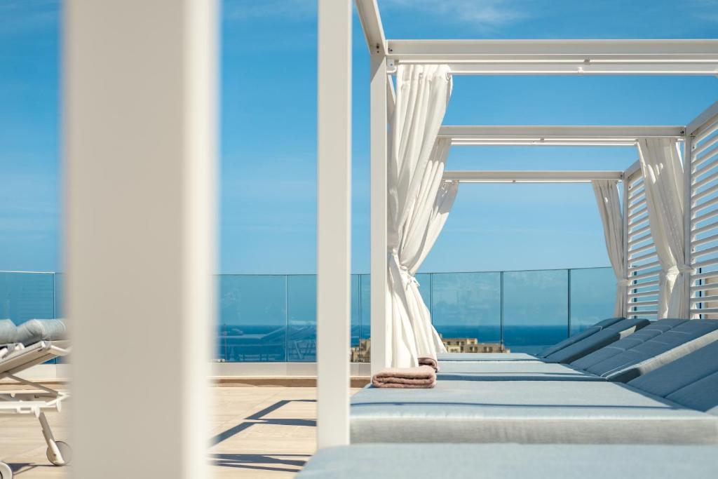 a room with a bed and a view of the ocean at Hyatt Regency Malta in St Julian's