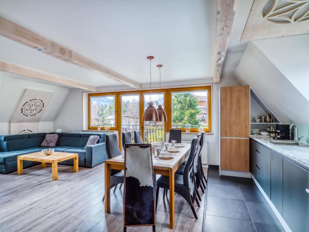 a kitchen and living room with a table and a couch at Apartament Śnieżny Deluxe Odkryj Zakopane in Kościelisko