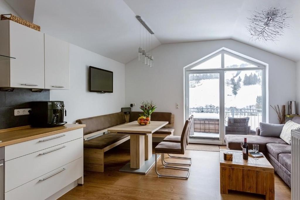 eine Küche und ein Wohnzimmer mit einem Sofa und einem Tisch in der Unterkunft Ferienwohnung Ettelsberg in Willingen in Willingen
