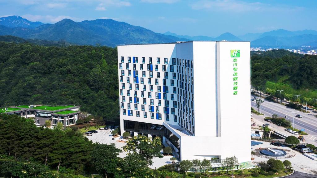 una vista aerea di un edificio con montagne sullo sfondo di Holiday Inn Express Luanchuan, an IHG Hotel a Luanchuan
