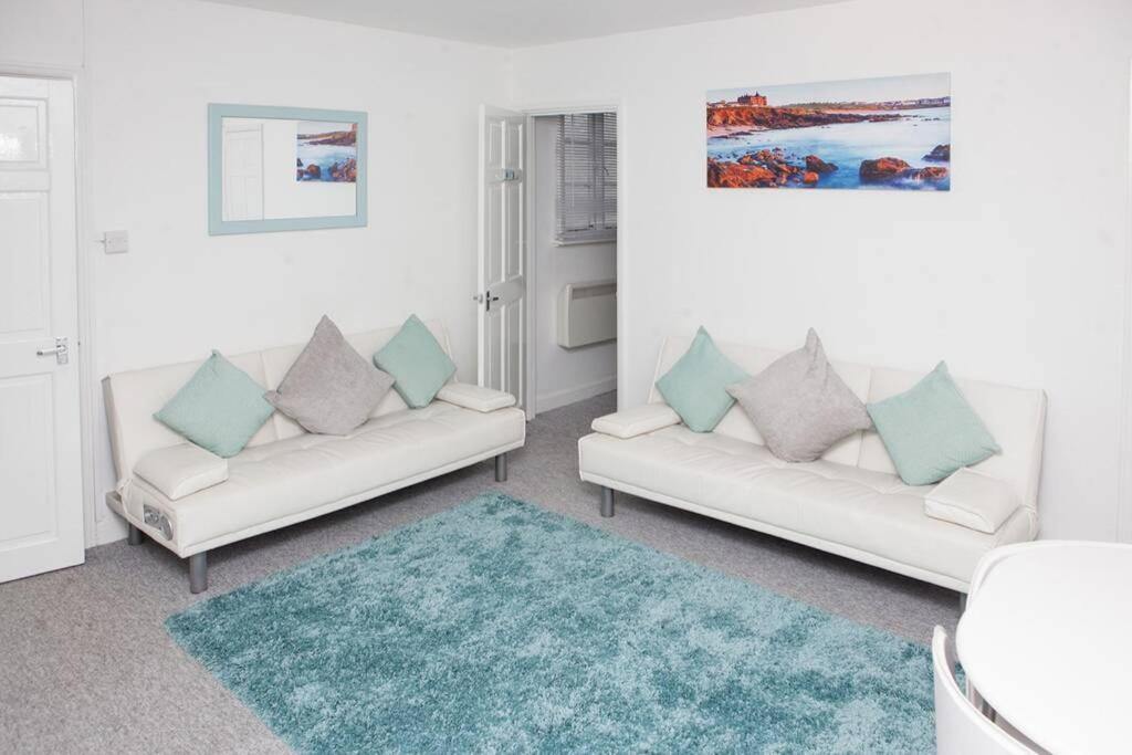 a living room with two white couches and a rug at Sunnyside - Back Road East St Ives - Sleeps 4 in St Ives