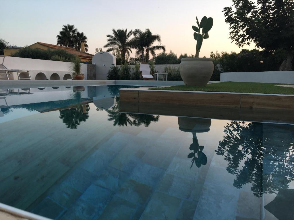 a swimming pool with a reflection in the water at Villa Zagara in Marsala