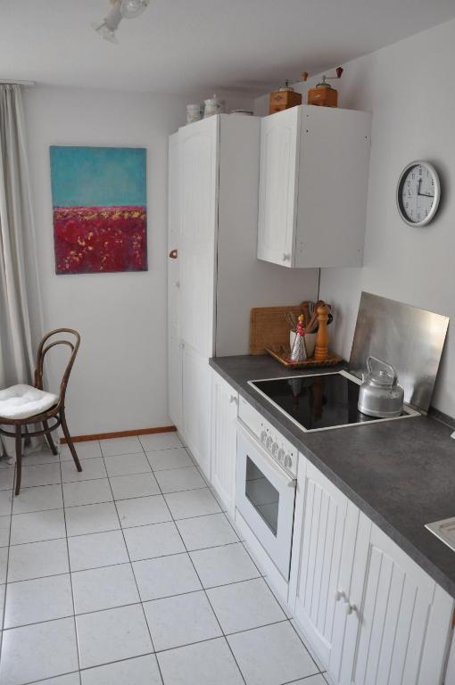 a kitchen with white cabinets and a stove top oven at Ferienwohnung Fischer in Frickingen