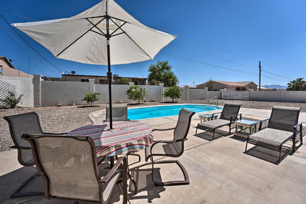 uma mesa e cadeiras com um guarda-sol ao lado de uma piscina em Bright Lake Havasu City Abode with Private Pool em Lake Havasu City