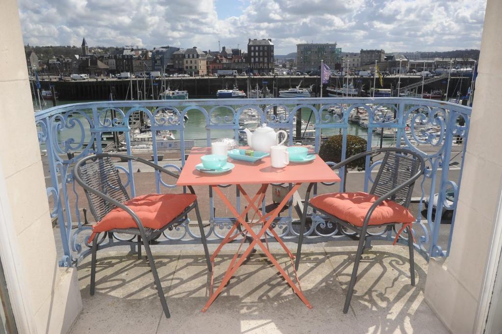 einen Tisch und Stühle auf einem Balkon mit Hafenblick in der Unterkunft L'Anvers vue port de plaisance 2 à 3 pers in Dieppe