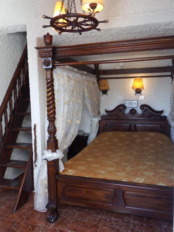 a bedroom with a canopy bed and a staircase at Hotel Porto Perissa in Perissa