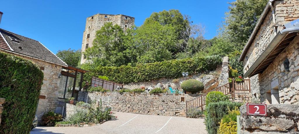 eine Gasse mit einer Steinmauer und einem Schloss in der Unterkunft Le Cottage du Château in Chaudenay-le-Château