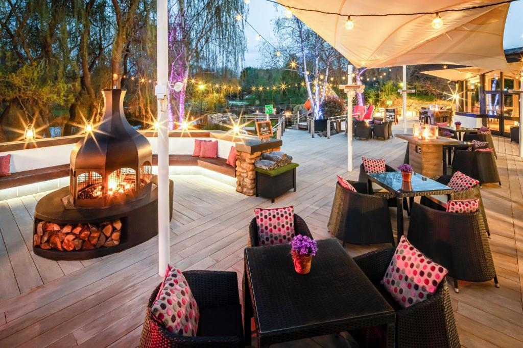 
a patio area with tables, chairs and umbrellas at Crowne Plaza Stratford-upon-Avon, an IHG Hotel in Stratford-upon-Avon
