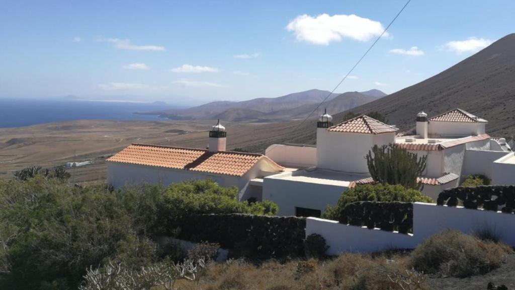 a white house on a hill with mountains in the background at Casa Angel in Mácher