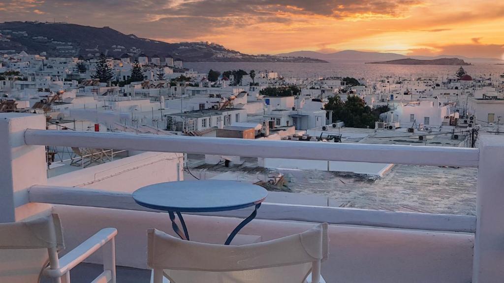 un tavolo e sedie su un balcone con vista sulla città di Lefteris a Mykonos Città