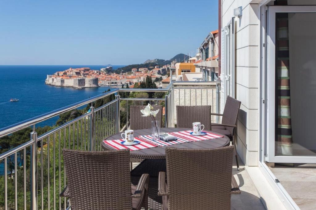 una mesa en un balcón con vistas al océano en Apartments Villa Ari, en Dubrovnik