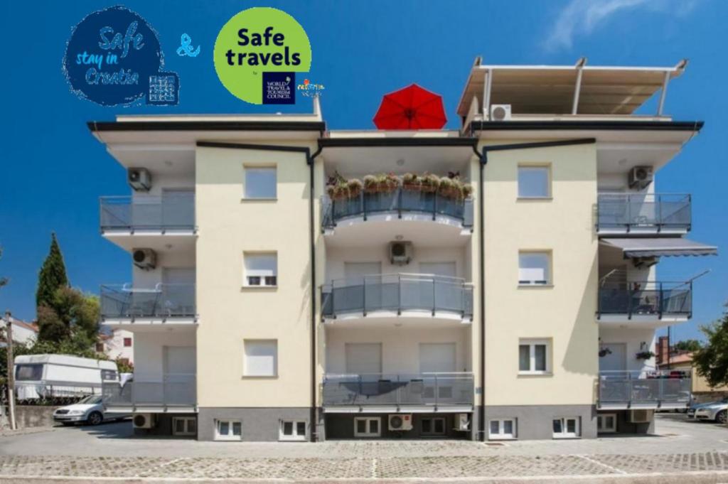 un edificio con sopra un ombrello rosso di Apartments Babo a Rovigno (Rovinj)