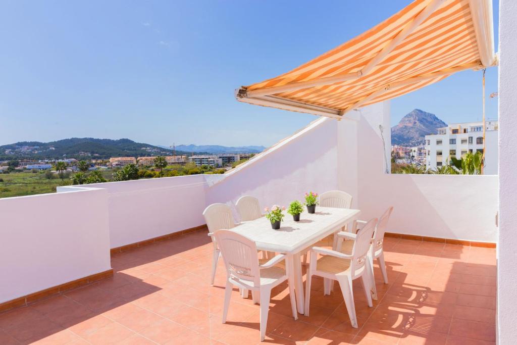 a white table and chairs on a balcony with a view at Salonica Duplex I Penthouse Javea Arenal by Rock Rentals in Jávea