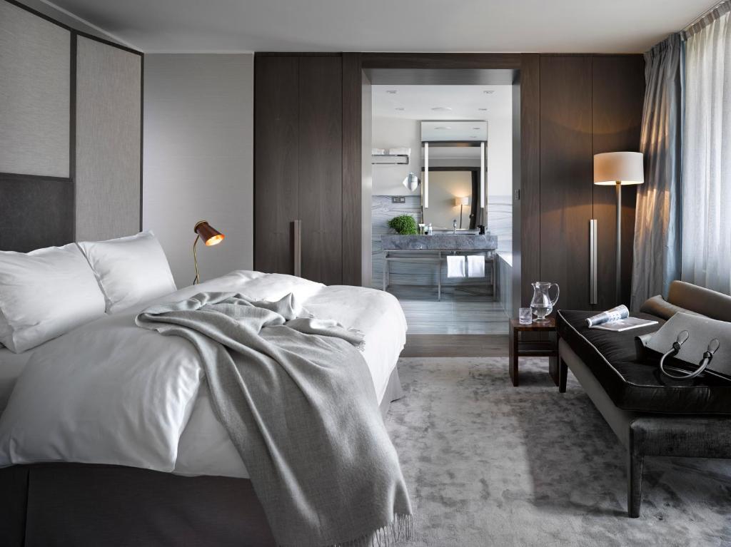 um quarto com uma cama grande e uma sala de estar em The Emblem Prague Hotel - Preferred Hotels & Resorts em Praga