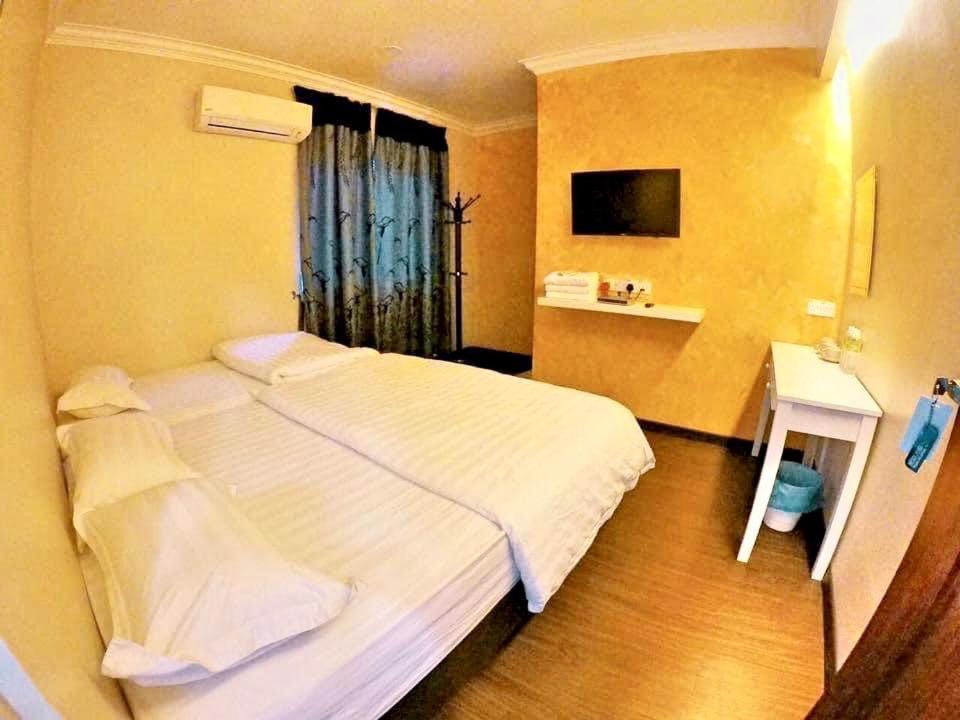 a bedroom with a large white bed and a window at 吉胆街坊民宿street Homes Inn Pulau Ketam in Bagan Pulau Ketam
