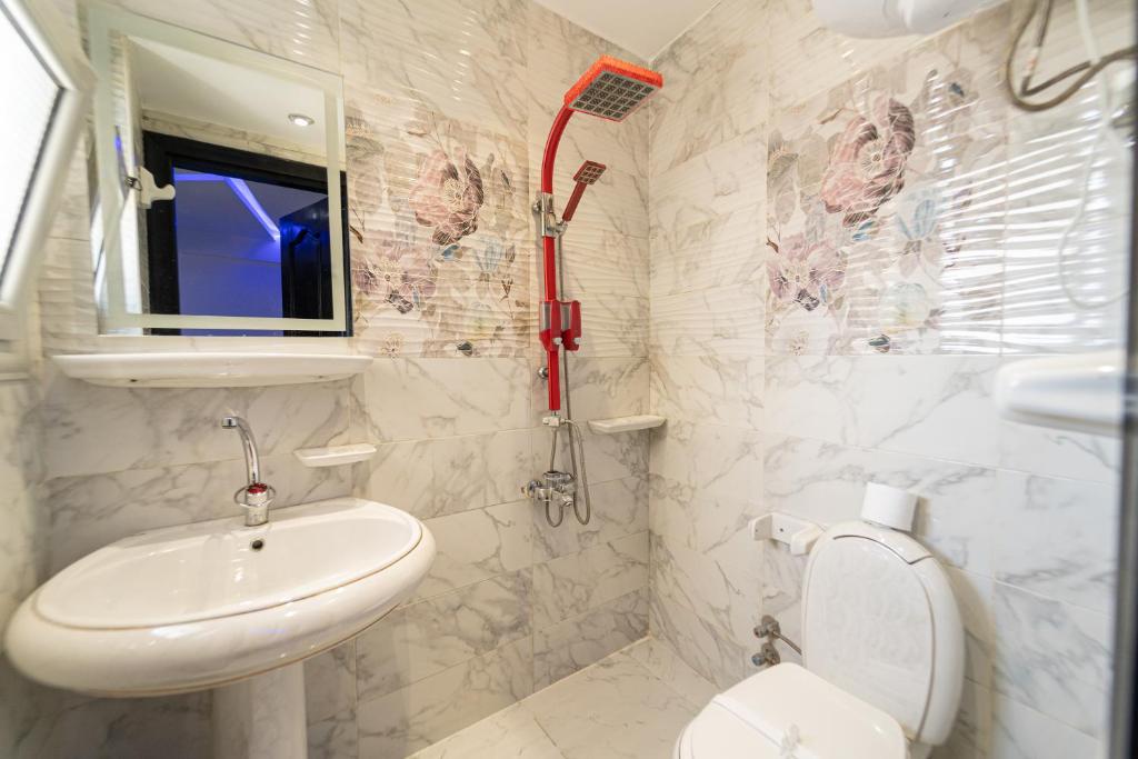 een witte badkamer met een wastafel en een toilet bij Gardenia Pyramids view inn in Caïro