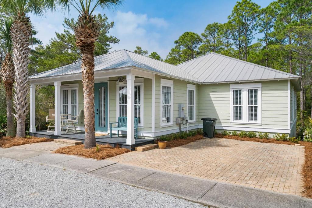 a white house with a palm tree in front of it at 248 Beach Bike Way in Inlet Beach