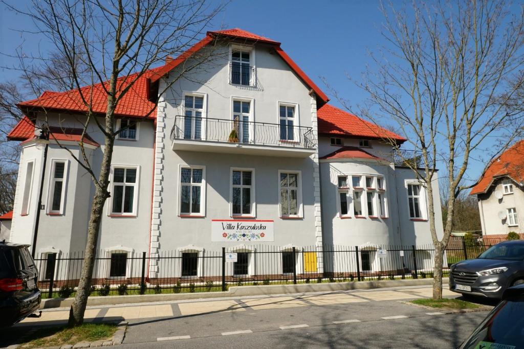 a large white house with an orange roof at Villa Kaszubska in Ustka