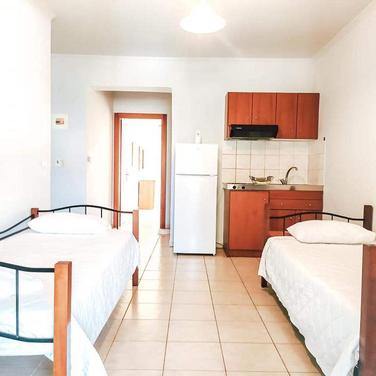a kitchen with two beds and a white refrigerator at Villa Valeria Thassos in Limenas