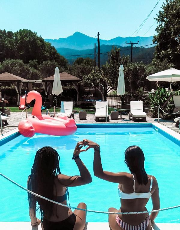two girls in bikinis sitting next to a swimming pool at Villa Valeria Thassos in Limenas
