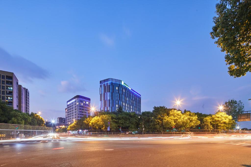 a city street with tall buildings at night at Holiday Inn Express Hangzhou Jiuzhou, an IHG Hotel in Hangzhou