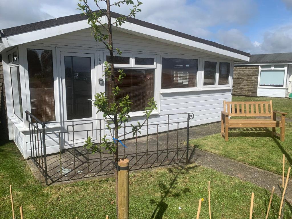a tiny house with a bench in the yard at Dartmouth 2 Bed Detached Chalet Number 144 in Dartmouth